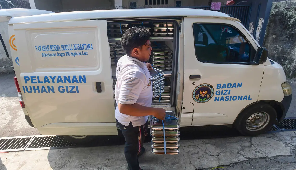 Petugas mendistribusikan ompremg makan bergizi gratis (MBG)  di Posyandu kawasan Limo, Depok, Jawa Barat, Selasa (14/7/2025).