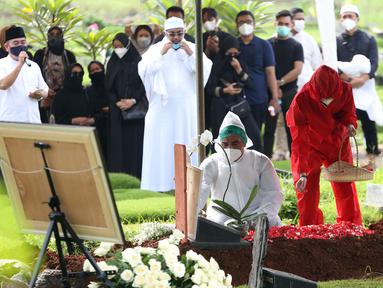 Suami presenter Rina Gunawan, Teddy Syach memandangi makam sang istri saat prosesi pemakaman di TPU Tanah Kusir, Jakarta, Rabu (3/3/2021). Rina Gunawan meninggal dunia di usia 46 tahun. (Kapanlagi.com/Budy Santoso)