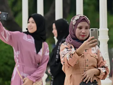 Umat Muslim berswafoto saat mereka berkumpul untuk sholat subuh untuk merayakan hari raya Idul Adha di Quirino Grandstand di Manila pada 28 Juni 2023. (AFP/JAM STA ROSA)