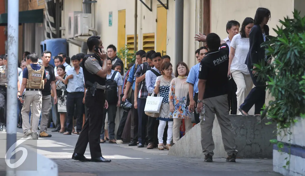 Sejumlah pekerja saat dievakuasi dari kantor mereka di Thamrin di Jakarta (14/1/2015). Beberapa ledakan dan suara senjata api terjadi di pusat ibukota Indonesia, Polisi mencurigai seorang melakukan aksi bom bunuh diri. (Liputan6.com/Gempur M Surya)