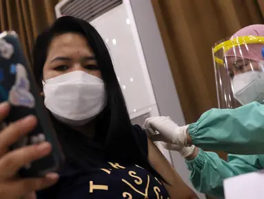 Petugas medis menyuntikkan vaksin COVID-19 kepada warga saat vaksinasi di Universitas Budi Luhur, Jakarta Selatan, Senin (21/6/2021). Vaksinasi tersebut menargetkan 1.000 masyarakat Jakarta berusia 18 tahun ke atas. (Liputan6.com/Angga Yuniar)