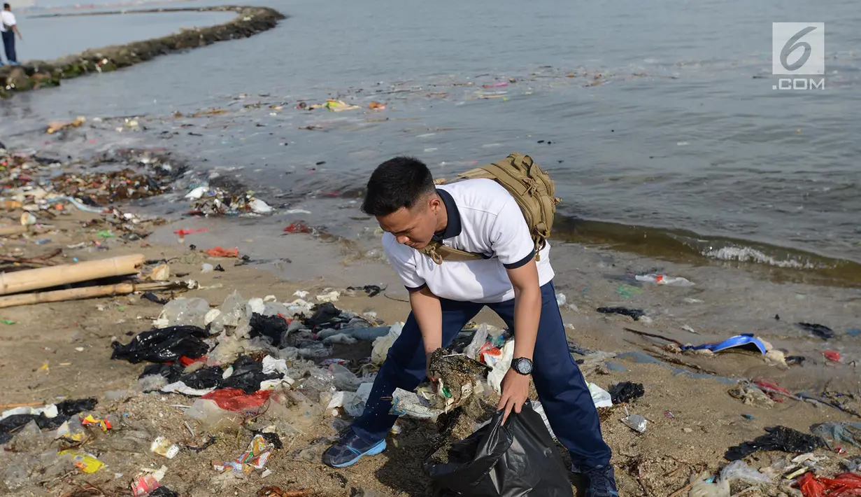 Prajurit TNI Angkatan Laut (AL)  membersihkan sampah di kawasan Pantai Ancol, Jakarta, Jumat (1/3). Kegiatan bersih-bersih itu menjadi giat yang bersifat keluarga dan melibatkan sejumlah elemen masyarakat. (Merdeka.com/ Imam Buhori)