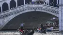 Gondola mengangkut wisatawan di sepanjang Grand Canal di bawah jembatan Rialto di Venesia (4/11/2019). Republik Venesia berdiri di kota ini dari abad ke-9 hingga ke-18. (AFP Photo/Miguel Medina)