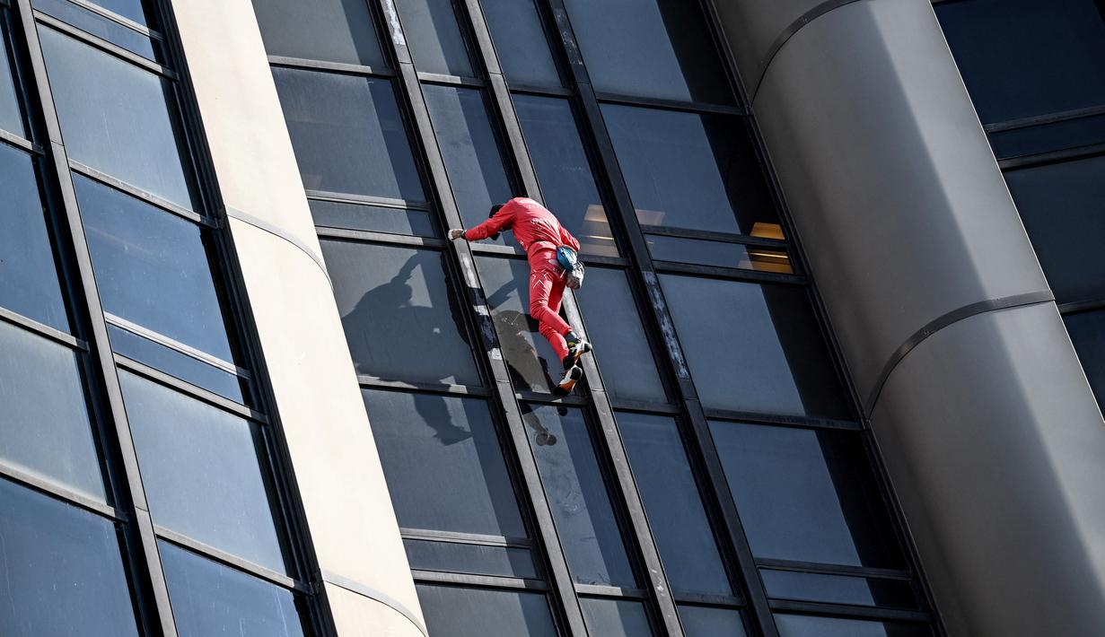 Alain Robert, pendaki bangunan pencakar langit asal Prancis memanjat Menara Montparnasse di Paris, Prancis, Rabu (12/10/2022). Alain Robert yang dikenal sebagai Spiderman Prancis itu kembali beraksi dengan memanjat Menara Montparnasse yang memiliki ketinggian 210 meter. (Bertrand GUAY/AFP)