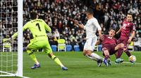 Pemain Real Madrid Casemiro (tengah) berebut bola dengan pemain Real Sociedad Robin Le Normand (kedua kanan) pada pertandingan sepak bola Liga Spanyol di Stadion Santiago Bernabeu, Madrid, Spanyol, 5 Maret 2022. Real Madrid menang 4-1. (PIERRE-PHILIPPE MARCOU/AFP)