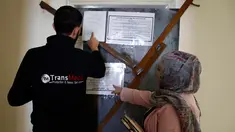 Karyawan Trans Media melihat pengumuman militer yang terpasang di pintu kantor mereka di Kota Hebron, Rabu (18/10). Pasukan Israel menggerebek perusahaan-perusahaan media di Tepi Barat dalam operasi besar-besaran memberantas penghasutan. (HAZEM BADER/AFP)