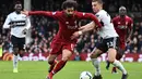 Aksi Mohamed Salah lewati gelandang Fulham, Joe Bryan pada laga lanjutan Premier League yang berlangsung di Stadion Craven Cottage, London, Minggu (17/3). Liverpool menang 2-1 atas Fulham. (AFP/Glyn Kirk)