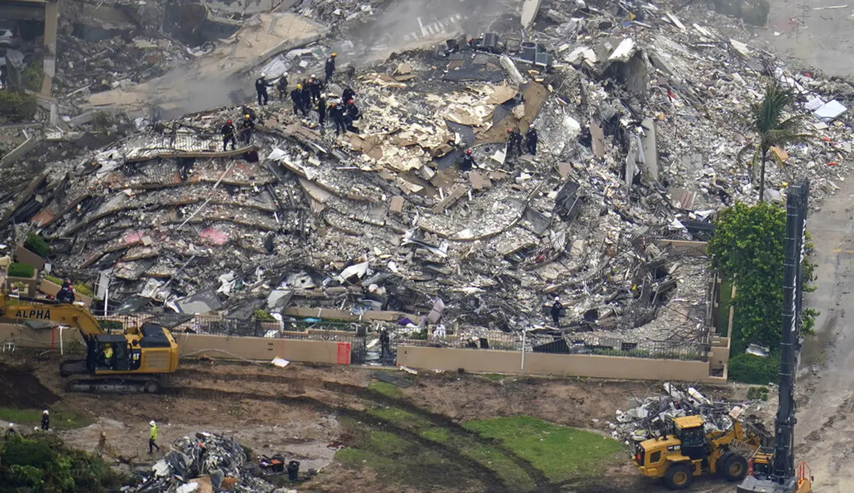 Foto udara memperlihatkan petugas pencarian dan penyelamatan bekerja di lokasi runtuhnya Champlain Towers South Condo, Surfside, Miami, Florida, Amerika Serikat, Jumat (25/6/2021). Tidak diketahui pasti berapa banyak orang yang berada di dalam gedung ketika runtuh. (AP Photo/Gerald Herbert)