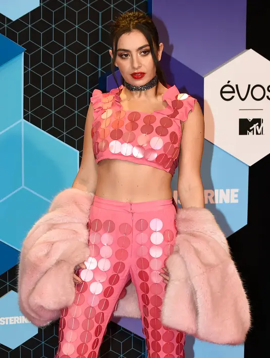 Penyanyi Inggris, Charli XCX berpose di karpet merah MTV Europe Music Awards 2016 di Ahoy Rotterdam, Belanda, Minggu (6/11). Charli mengenakan setelan crop top merah muda menyala dengan motif polkadot. (JOHN THYS/AFP)