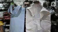 Abdullah menunjukkan plastik sekali pakai dan kantong ramah lingkungan yang dijual di Pasar Tebet Barat, Jakarta, Selasa (30/6/2020). Jelang pemberlakuan larangan plastik sekali pakai, Abdullah mengaku penjualan kantong kresek di tokonya menurun hingga 30 persen. (merdeka.com/Iqbal S Nugroho)