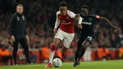 Pemain Arsenal, Joe Willock berebut bola dengan pemain West Ham United, Domingos Quina pada laga perempat final Piala Liga Inggris di Emirates Stadium, Selasa (20/12). Gol tunggal Danny Welbeck memberikan Arsenal kemenangan 1-0. (AP /Alastair Grant)