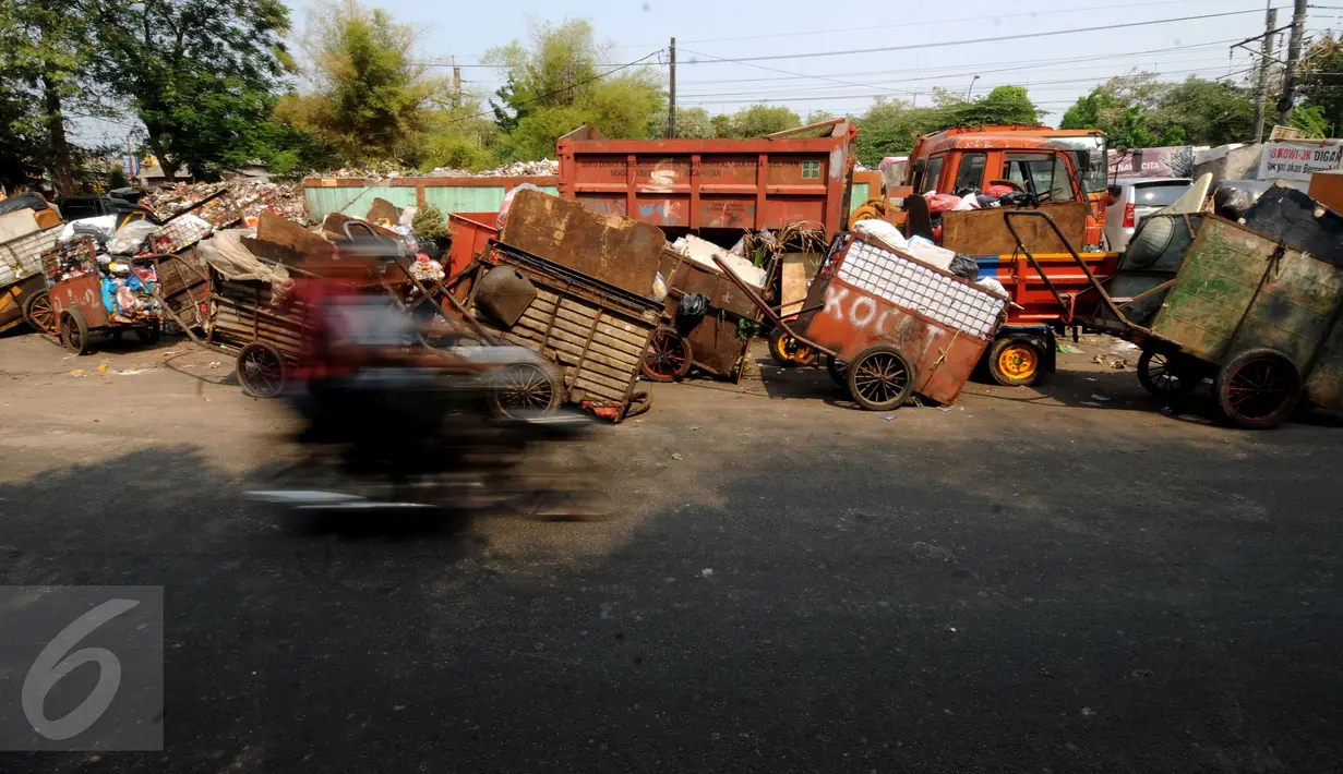 Warga melintas di depan Tempat Pembuangan Sampah Sementara Kalibata, Jakarta, Rabu (4/11/2015). Sejak Senin (2/11) lalu, sampah-sampah yang ada di TPSS Kalibata belum sepenuhnya terangkut. (Liputan6.com/Helmi Fithriansyah)