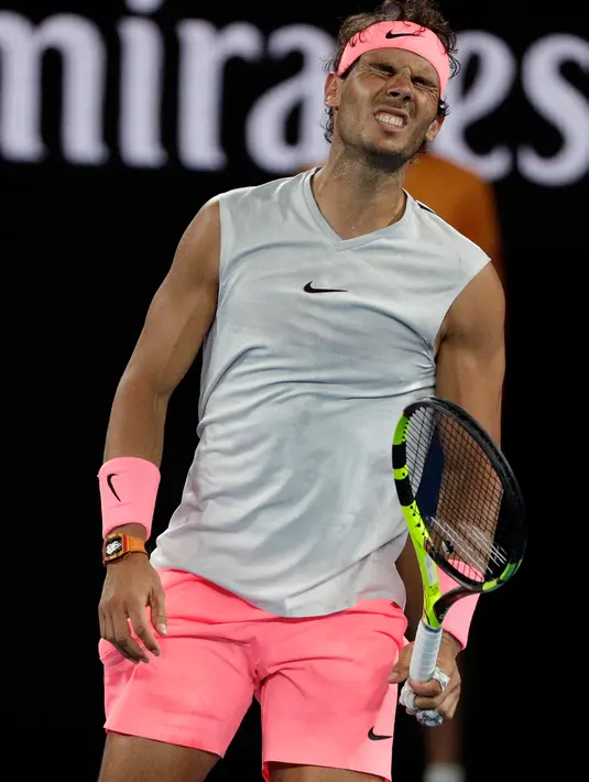 Petenis Spanyol, Rafael Nadal menahan sakit saat bertanding melawan petenis Kroasia, Marin Cilic di perempat final Australia Terbuka 2018, Selasa (23/1). Unggulan teratas itu sudah mengalami masalah pada paha kanannya di set keempat. (AP/Dita Alangkara)