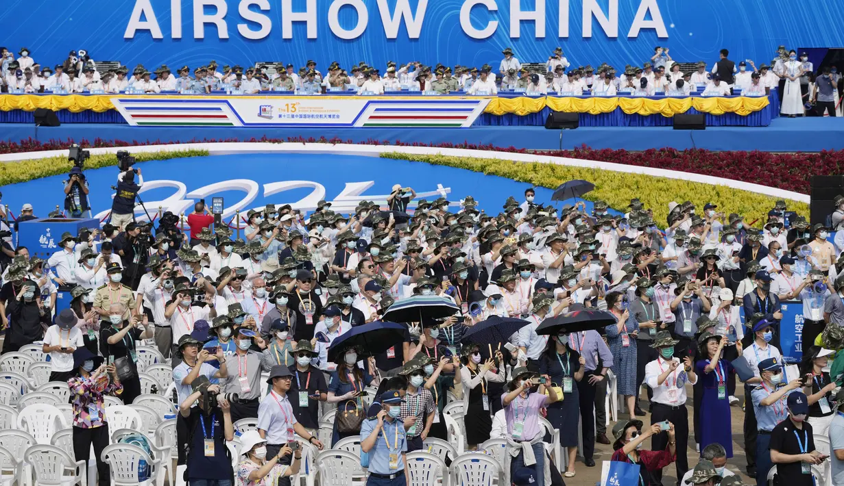 Pengunjung menonton pertunjukan udara selama Pameran Penerbangan dan Antariksa Internasional China ke-13, juga dikenal sebagai Pertunjukan Udara China 2021 di Zhuhai di provinsi Guangdong, China (38/9/2021). (AP Photo/Ng Han Guan)