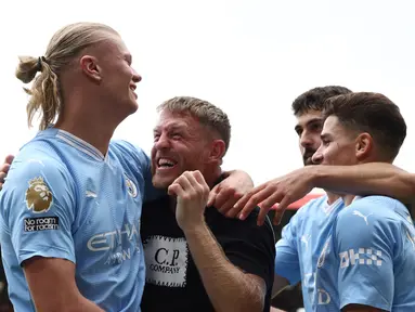 Striker Manchester City #09 Erling Haaland (kiri) merayakan mencetak gol pertama bersama penggemar Man City dan rekan satu timnya saat melawan Sheffield United pada pekan ketiga Liga Inggris 2023/2024 di Bramall Lane, Minggu (27/8/2023). (Photo by Darren Staples / AFP)