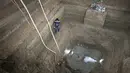 Peneliti saat berada didalam lubang yang masih terdapat air di makam penguburan kuda di Luoyang, Cina. Lubang yang memiliki panjang 25 kaki, Lebar 20 kaki dan kedalaman sembilan kaki terdapat 13 kuda dan enam kereta. (Dailymail) 