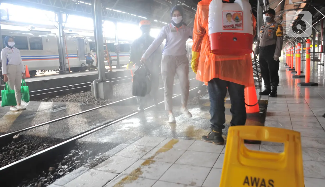 Petugas menyemprotkan larutan disinfektan kepada penumpang yang turun di Stasiun Kereta Api (KA) Tawang, Semarang, Sabtu (28/3/2020). Selain sterilisasi, petugas juga melakukan pencatatan penumpang yang turun untuk data pengawasan guna menekan penularan Virus Corona (COVID-19) (Liputan6.com/Gholib)