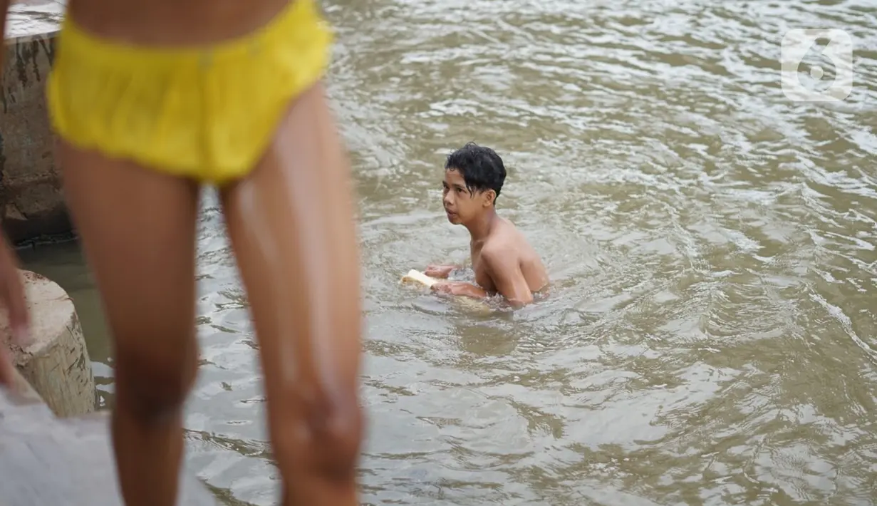 Seorang anak berenang di aliran Sungai Kalimalang, Jakarta, Selasa (18/8/2020). Keterbatasan ekonomi menyebabkan anak-anak tersebut memanfaatkan Sungai Kalimalang sebagai tempat berenang, meskipun berbahaya bagi keselamatan dan kesehatan mereka. (Liputan6.com/Immanuel Antonius)