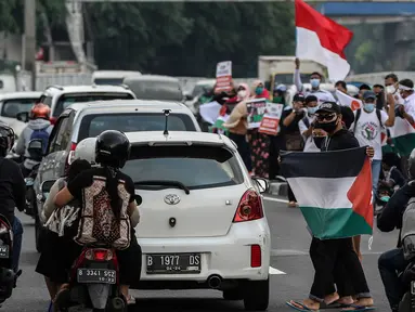 Masyarakat membawa bendera Palestina di jalan Basuki Rahmat, Jakarta, Kamis (20/5/2020). Aksi masyarakat tersebut untuk mengutuk penyerangan Israel ke Palestina yang telah menyebabkan ratusan korban jiwa. (Liputan6.com/Johan Tallo)