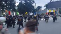 Polisi mengejar massa mahasiswa yang menggelar demo penolakan harga BBM naik hjngga ke perempatan Jalan CIkapayang Dago, Kota Bandung, Kamis (22/9/2022). Liputan6.com/Dikdik Ripaldi