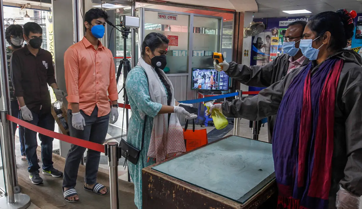 Pegawai menyemprotkan cairan pembersih tangan kepada seorang wanita di sebuah pasar di Dhaka, Bangladesh, Senin (11/5/2020). Jalan-jalan utama Dhaka kembali ramai sehari setelah toko-toko dan pasar kembali dibuka secara terbatas mengikuti aturan pemerintah. (Xinhua/Stringer)