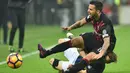 Striker AC Milan, Suso, terjatuh saat berebut bola dengan bek Inter Milan, Cristian Ansaldi, pada laga pekan ke-13 Serie A di Stadion San Siro, Minggu (20/19/2016). (AFP/Giuseppe Cacace)