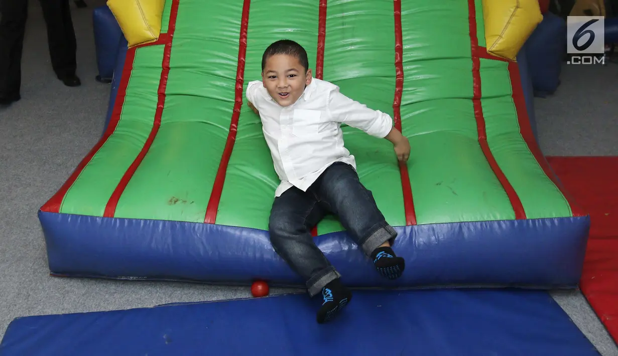 Ekspresi Kellen saat bermain prosotan di kawasan Tebet, Minggu (27/08). Anak-anak ini asyik bermain saat menghadiri acara potong rambut anak kedua Ayu Dewi. (Liputan6.com/Herman Zakharia)