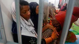 Muslim Rohingya duduk di balik jerusi besi di sebuah kantor polisi di Provinsi Satun, Thailand Selatan pada 11 Juni 2019. Sebanyak 65 Muslim Rohingya ditemukan di sebuah kapal yang nyaris karam di bagian selatan negara itu. (Department of National Parks Wildlife and Plant Conservation via AP)