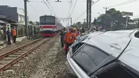 Evakuasi kendaraan minibus yang tertabrak KRL di perlintasan palang pintu manual Rawageni, Kecamatan Cipayung, Kota Depok. (Liputan6.com/Dicky Agung Prihanto)