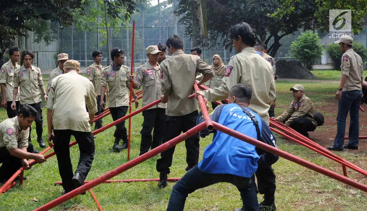 Anggota Tagana Kota Tangerang Selatan menyusun kerangka besi di Situ Gintung, Ciputat, Kamis (12/7). Pelatihan Shelter (pengungsian) tersebut di gelar untuk melatih kekompakan dan kecekatan dalam menghadapi bencana. (Merdeka.com/Arie Basuki)