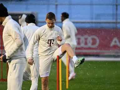 Gelandang Bayern Munchen #06 Joshua Kimmich (kanan) menghadiri sesi latihan saat hujan salju menjelang lanjutan Liga Champions 2023-2024, di Munich, Jerman selatan, Selasa (28/11/2023). (LUKAS BARTH / AFP)