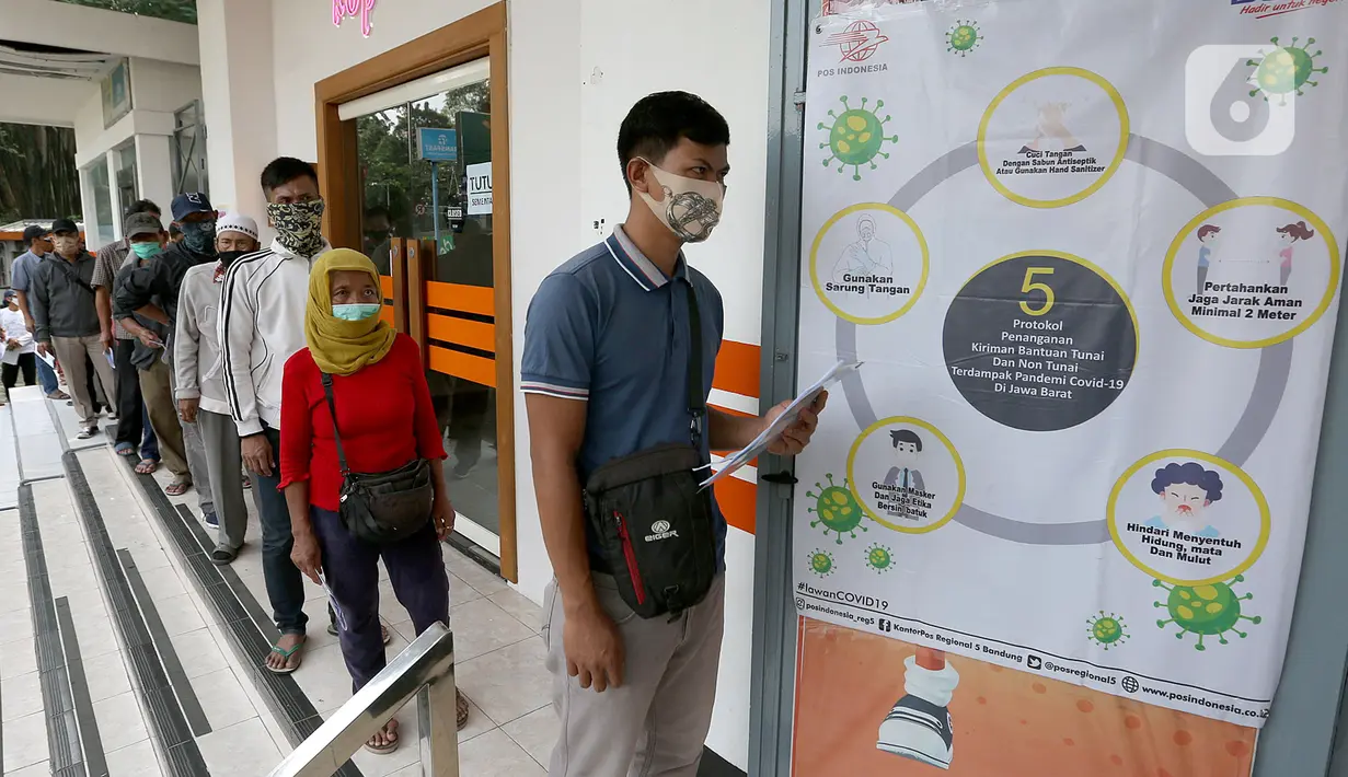 Keluarga Penerima Manfaat (KPM) dengan mengenakan masker dan menjaga jarak antre mencairkan bantuan sosial tunai di Kantor Pos Bogor, Rabu (13/5/2020). Bantuan langsung tunai bagi yang terdampak COVID-19 itu senilai Rp 600 ribu per bulan selama tiga bulan ke depan. (merdeka.com/Arie Basuki)