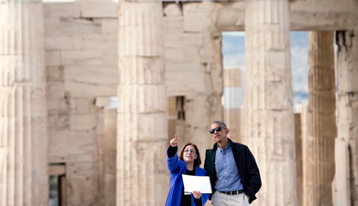 Presiden AS Barack Obama mendengarkan penjelasan dari Direktur Departemen Kebudayaan Ephorate of Antiquities untuk Athena, Eleni Banou saat berkunjung ke Athena, Yunani (16/11). (AFP/Brendan Smialowski)