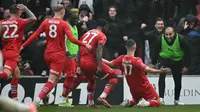 Penyerang Inggris Leyton Orient #17, Jamie Donley (2R), merayakan gol bersama rekan satu timnya setelah tendangan jarak jauhnya mengenai mistar gawang dan dibelokkan ke gawangnya sendiri oleh penjaga gawang Manchester City asal Jerman #18, Stefan Ortega, untuk mencetak gol pertama mereka selama pertandingan putaran keempat Piala FA Inggris antara Leyton Orient dan Manchester City di Stadion Gaughan Group, Brisbane Road di London timur pada 8 Februari 2025. (JUSTIN TALLIS/AFP)