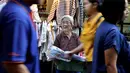 Seorang wanita lansia menjual topi mandi  di sebuah gang, yang terkenal dengan pedagang kaki lima dan pakaian, di pusat Bangkok, Thailand (8/11/2019). (AP Photo/Aijaz Rahi)