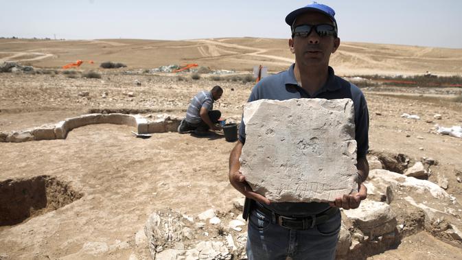 Yaser Alamor dari otoritas barang antik Israel memperlihatkan batu reruntuhan salah satu masjid kuno, di kota Rahat, gurun Negev pada 18 Juli 2019. Peneliti menyebut masjid terkait adalah yang pertama dibangun setelah kedatangan Islam di tempat yang dikenal sebagai Israel. (MENAHEM KAHANA/AFP)