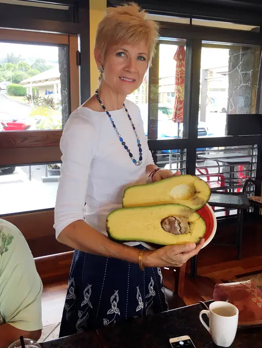 Dalam foto 28 November 2017, Pamela Wang berpose dengan buah alpukat super jumbo di Kealakekua, Hawaii. Guinness World Records saat ini sedang menentukan apakah alpukat tersebut merupakan alpukat terberat yang pernah ditemukan. (AP Photo/Mary Lou Knurek)