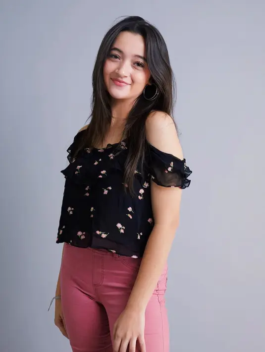 Wanita kelahiran Mentogo Bay ini tampil manis dengan sabrina bermitif bunga-bunga.  Penampilan aktris sekaligus penyanyi ini terlihat lebih ceria dengan celana jeans berwarna merah muda. (Liputan6.com/IG/@megandomani1410)