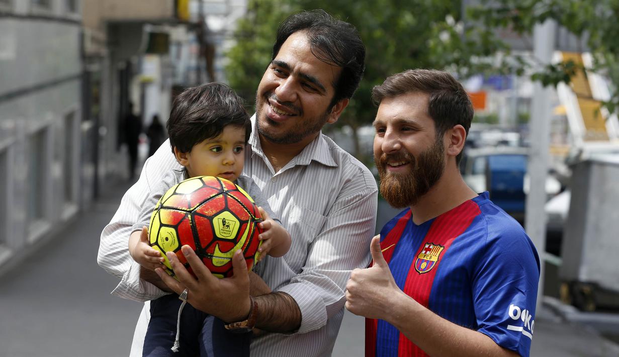 Reza Parastesh, seorang warga Iran yang memiliki wajah mirip Lionel Messi diajak foto bareng oleh warga di jalanan Tehran, Iran, Senin (8/5/2017). (AFP/Atta Kenare)