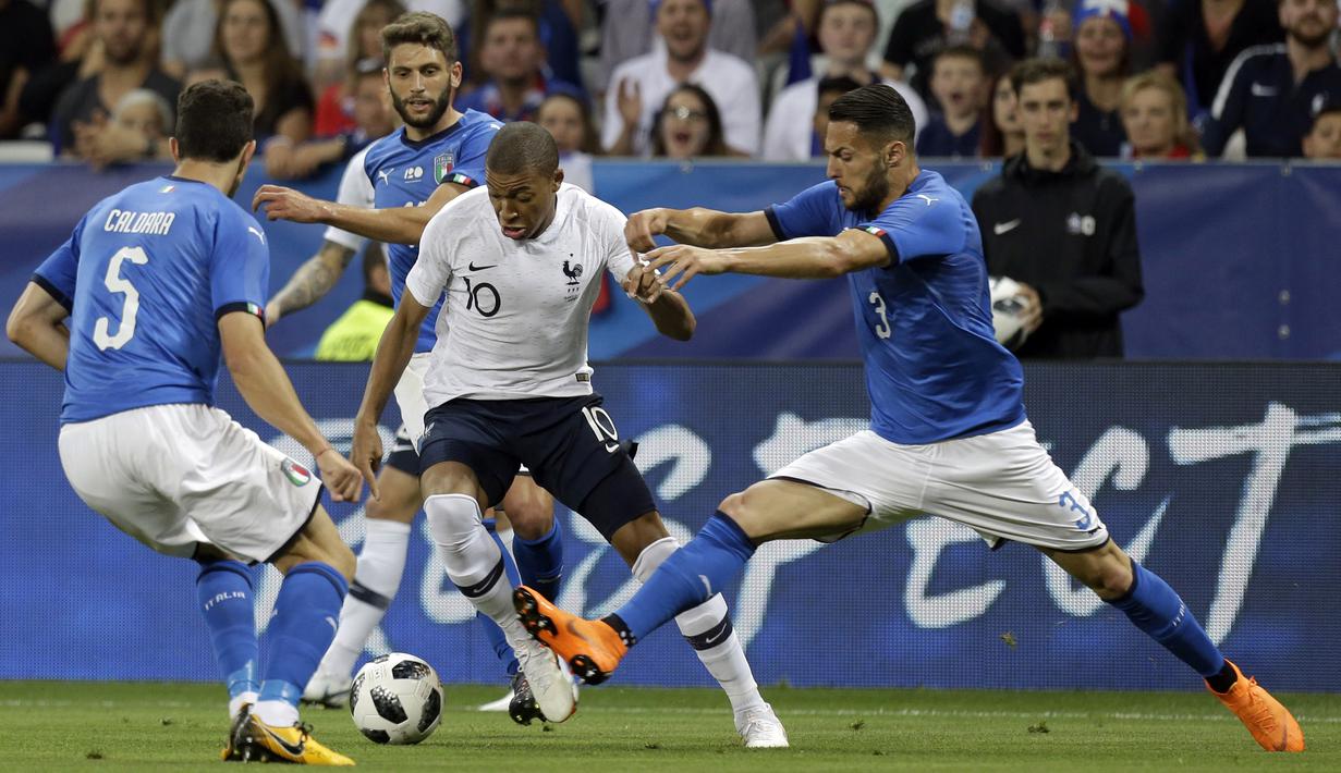 Pemain Prancis, Kylian Mbappe berusaha keluar dari kepungan para pemain Italia pada laga uji coba di Allianz Riviera stadium, Nice, (1/6/2018). Prancis menang 3-1. (AP/Claude Paris)