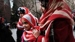 Sejumlah wanita memakai kerudung bermotif bendera AS selama perayaan Hari Hijab Sedunia di depan Balai Kota, New York, Rabu (1/2). Nazma Khan mengagaskan Hari Hijab Sedunia untuk menumbuhkan toleransi beragama. (Spencer Platt / Getty Images / AFP)