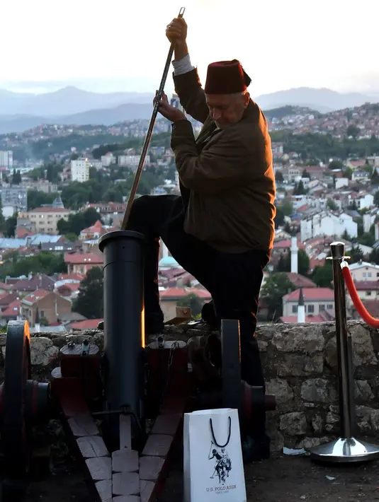Seorang pria Muslim Bosnia bersiap menyalakan meriam kembang api di kota tua Sarajevo, (16/5). Tembakan meriam kembang api saat matahari terbenam menandai akhir dari puasa selama bulan suci Ramadan. (AFP Photo/Elvis Barukcic)