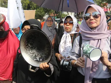 Sejumlah ibu-ibu yang tergabung dalam Barisan Emak-Emak Militan (BE2M) Indonesia menggelar aksi di seberang Istana Merdeka, Jakarta, Rabu (18/7). Mereka menuntut Presiden Jokowi menurunkan harga sembilan bahan pokok (sembako). (Liputan6.com/Arya Manggala)