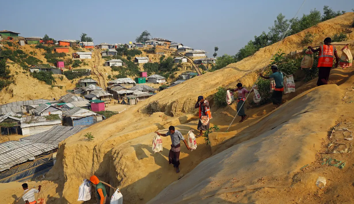 Pengungsi Rohingya membawa batu bata ke lokasi konstruksi di kamp Balukhali di Cox's Bazar, Bangladesh (8/4). (Reuters/Mohammad Ponir Hossain)
