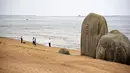 Sepasang pengantin berpose untuk foto pernikahan di sebuah pantai di Rizhao, Provinsi Shandong, China timur (9/7/2020). (Xinhua/Wang Kai)