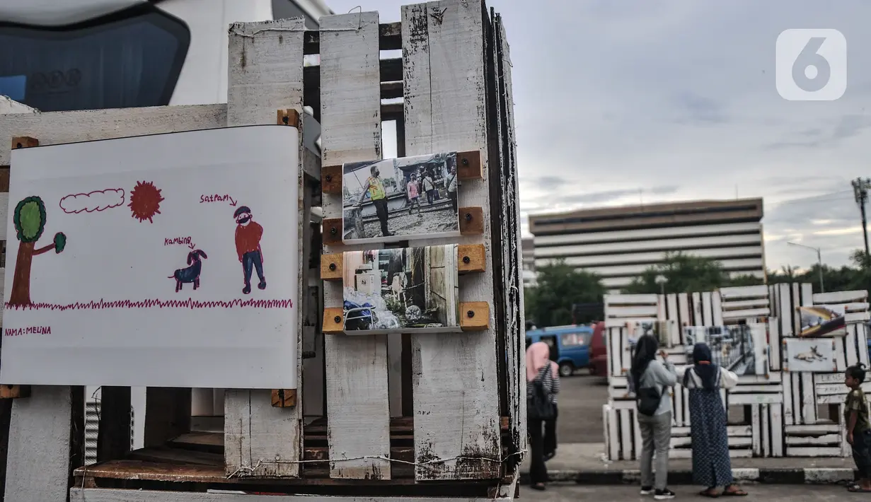 Warga melihat karya foto yang ditampilkan dalam pameran Lensa Anak Terminal di Terminal Depok Baru, Jawa Barat, Minggu (12/12/2021). Pameran tersebut mengisahkan potret kehidupan di Terminal Depok Baru dan sekitarnya dari sudut pandang anak-anak terminal. (merdeka.com/Iqbal S Nugroho)