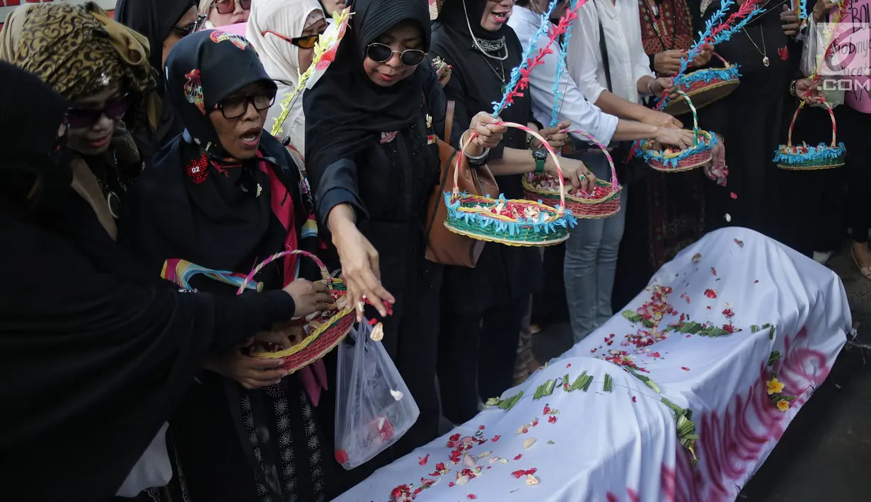 Ibu-ibu yang mengatasnamakan diri emak-emak pendukung pasangan calon 02 Prabowo Subianto-Sandiaga Uno melakukan aksi tabur bunga di atas keranda mayat yang mereka bawa saat menggelar unjuk rasa di depan kantor KPU, Jakarta, Kamis (2/5/2019). (Liputan6.com/Faizal Fanani)