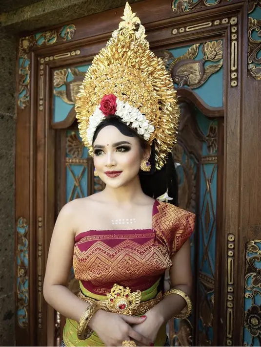 Pemiliki nama lengkap Ni Luh Ketut Mahalini Ayu Raharja juga cantik mengenakan pakaian adat Bali, dengan stagen warna merah gold, ditambah slendang dan bawahan songket Bali. Lengkap dengan mahkota emas dan bunga pada hiasan kepalanya, serta subeng dan gelang khas Bali. (@mahaliniraharja)