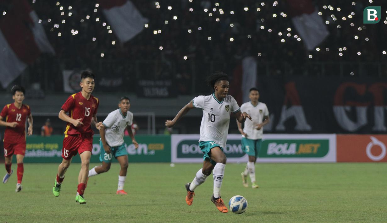 <p>Pemain Timnas Indonesia U-19, Ronaldo Joybera R Junior Kwateh (kanan) berusaha melewati pemain Timnas Vietnam U-19 saat laga Grup A Piala AFF U-19 2022 antara Timnas Indonesia U-19 melawan Timnas Vietnam U-19 di Stadion Patriot Candrabhaga, Bekasi, Jawa Barat, Sabtu (02/07/2022). (Bola.com/Ikhwan Yanuar)</p>