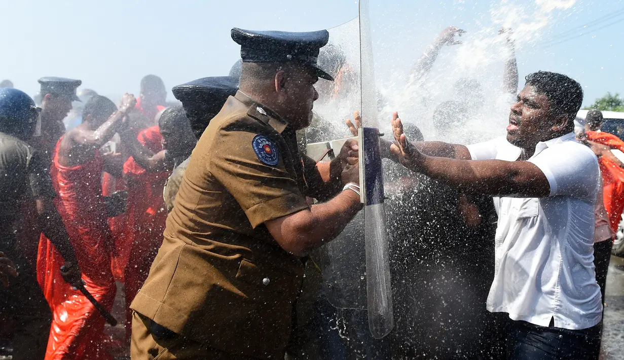 Sejumlah biksu dan aktivis bentrok dengan polisi saat aksi protes di kota pelabuhan selatan Hambantota, Sri Lanka (7/1). Akibat aksi ini, peresmian yang dihadiri oleh Perdana Menteri Ranil Wickeremesinghe, akhirnya tertunda. (AFP/Ishara S. Kodikara)